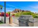 Outdoor grill with mountain views, complemented by artistic decor and lush landscaping at 4218 E Palo Verde Dr, Phoenix, AZ 85018