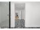 Bright hallway featuring white walls, zebra carpet, and modern glass door, with a view to the other rooms at 4218 E Palo Verde Dr, Phoenix, AZ 85018
