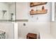 Bright bathroom features an open shower with a built-in bench and floating wood shelves at 42711 N 45Th Dr, Phoenix, AZ 85087