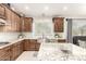 Bright kitchen featuring granite countertops, stainless sink, and wood cabinetry with ample storage space at 42711 N 45Th Dr, Phoenix, AZ 85087