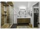 A full bathroom with a shower and a double vanity with two mirrors and an open closet at 42760 W Magnolia Rd, Maricopa, AZ 85138