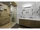 A full bathroom with a shower and a double vanity with two mirrors at 42760 W Magnolia Rd, Maricopa, AZ 85138