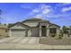 Charming single-story home featuring a three-car garage, desert landscaping, and a welcoming front entrance at 42760 W Magnolia Rd, Maricopa, AZ 85138