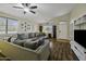 Comfortable living room with vaulted ceilings, ceiling fan, wood floors, and a large sectional sofa at 42760 W Magnolia Rd, Maricopa, AZ 85138