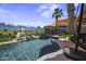 Backyard pool oasis featuring a rock waterfall, vibrant murals, artificial turf, and sun umbrellas at 42760 W Magnolia Rd, Maricopa, AZ 85138