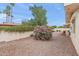 The backyard has rock landscaping, mature shrubs, bushes, and a block fence at 4306 E Dragoon Cir, Mesa, AZ 85206