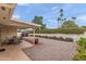 A low maintenance backyard with gravel landscaping, covered patio, block wall and mature trees at 4306 E Dragoon Cir, Mesa, AZ 85206