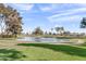 Picturesque golf course with pond, mature trees, walking path, and green fairways at 4306 E Dragoon Cir, Mesa, AZ 85206