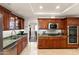 Well-appointed kitchen featuring granite countertops, stainless steel appliances, and cherry wood cabinets at 4306 E Dragoon Cir, Mesa, AZ 85206