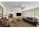 Comfortable living room featuring neutral tones, ceiling fan, shuttered windows, and an open floor plan at 4306 E Dragoon Cir, Mesa, AZ 85206