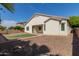 Exterior view of house shows tidy backyard with gravel, grass patch, patio, and mature trees at 4335 E Sleighbell Dr, Gilbert, AZ 85297