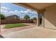 Covered patio overlooks the serene backyard with a patch of grass and secure brick wall at 4335 E Sleighbell Dr, Gilbert, AZ 85297