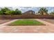 Backyard featuring a tidy grass patch and brick-lined landscape against a high brick wall at 4335 E Sleighbell Dr, Gilbert, AZ 85297