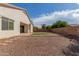 Backyard featuring gravel, lawn, brick border, and block wall fence, with patio doors on house at 4335 E Sleighbell Dr, Gilbert, AZ 85297