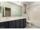 Bathroom featuring double sinks, a large mirror, bathtub with shower, and tiled floors at 4335 E Sleighbell Dr, Gilbert, AZ 85297