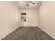Cozy bedroom with neutral carpeting, a ceiling fan, a window, and a clean, minimalist aesthetic at 4335 E Sleighbell Dr, Gilbert, AZ 85297