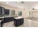Modern kitchen features dark cabinets, stainless appliances, an island, and adjacent living area at 4335 E Sleighbell Dr, Gilbert, AZ 85297