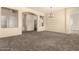 Expansive carpeted living room with neutral walls, arched doorways, and ample space, ideal for entertaining at 4335 E Sleighbell Dr, Gilbert, AZ 85297