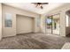 Bright living room features neutral walls, plush carpet, and sliding glass door to backyard at 4335 E Sleighbell Dr, Gilbert, AZ 85297