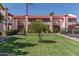 Exterior of complex on a sunny day with green lawn and mature landscaping at 4401 E Hubbell St # 57, Phoenix, AZ 85008