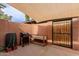 Private patio with a brick perimeter, sun shade, BBQ, and wooden planter box at 4401 E Hubbell St # 57, Phoenix, AZ 85008