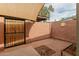 Enclosed patio with brick flooring, block wall, garden bed, and a metal security gate at 4401 E Hubbell St # 57, Phoenix, AZ 85008