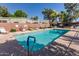 Inviting community pool with clear blue water, bordered by lounge chairs and tropical landscaping at 4401 E Hubbell St # 57, Phoenix, AZ 85008