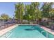 Serene community pool area with mature trees, lounge chairs, and covered parking nearby at 4401 E Hubbell St # 57, Phoenix, AZ 85008