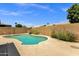 Desert backyard showcasing a refreshing pool, desert landscaping, and perimeter privacy fence at 4434 E Thistle Landing Dr, Phoenix, AZ 85044
