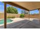 Backyard covered patio with pool, desert landscaping, hardscape and privacy fencing at 4434 E Thistle Landing Dr, Phoenix, AZ 85044