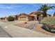 A lovely home exterior with a desert landscape, a tan exterior, and an attached garage at 4434 E Thistle Landing Dr, Phoenix, AZ 85044
