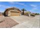 Exterior view of a charming tan home with a two-car garage and desert landscaping at 4434 E Thistle Landing Dr, Phoenix, AZ 85044
