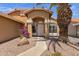 Close up of a tan home with a desert landscape and an arched entryway at 4434 E Thistle Landing Dr, Phoenix, AZ 85044