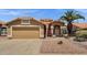Charming home with a tan exterior, desert landscaping, and a two-car garage at 4434 E Thistle Landing Dr, Phoenix, AZ 85044