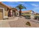 Inviting home with desert landscaping, a tan exterior, and a charming front entrance at 4434 E Thistle Landing Dr, Phoenix, AZ 85044