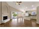 Open-concept room with fireplace, wood floors, and kitchen island at 4434 E Thistle Landing Dr, Phoenix, AZ 85044