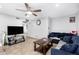 Bright living room with television, ceiling fan, and comfortable blue sofa at 4513 W Yucca St, Glendale, AZ 85304