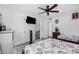 Neutral bedroom features a ceiling fan, closet, mounted tv, and an ensuite bathroom at 4513 W Yucca St, Glendale, AZ 85304