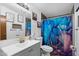 Bathroom features a colorful shower curtain, vanity sink, decorative wall art, and a toilet at 466 N Rennick Dr, Apache Junction, AZ 85120