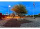 Front yard features native trees and a fire pit, with a street light and a stop sign in the background at 466 N Rennick Dr, Apache Junction, AZ 85120