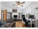 Home office with wood-look floors features a desk, leather couch, ceiling fan, and display cabinets at 466 N Rennick Dr, Apache Junction, AZ 85120