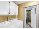 Laundry room features a stacked washer and dryer, cabinets, and access to the walk-in shower at 466 N Rennick Dr, Apache Junction, AZ 85120