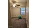 Cozy bedroom featuring plush carpeting, a ceiling fan, and natural light from a window at 4721 E Abraham Ln, Phoenix, AZ 85050