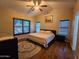Cozy main bedroom with hardwood floors, a ceiling fan, and natural light from windows overlooking the outdoor space at 4721 E Abraham Ln, Phoenix, AZ 85050