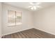 A clean, bright bedroom featuring wood floors, a window with blinds, and a ceiling fan at 4832 W Golden Ln, Glendale, AZ 85302