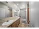 Bright bathroom features a dual sink vanity with mosaic tile backsplash and shower with glass doors at 500 N 67Th Ave # 52, Phoenix, AZ 85043