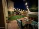 Inviting backyard with patio furniture, string lights, and a well-manicured lawn at 546 E San Carlos Way, Chandler, AZ 85249