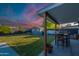 A covered patio with outdoor dining, leading to a lush backyard with a storage shed at 5801 W Cortez St, Glendale, AZ 85304