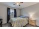 A cozy bedroom featuring natural light, dark curtain panels, ceiling fan and neutral carpeting at 5801 W Cortez St, Glendale, AZ 85304