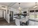 Bright kitchen features stainless appliances, modern finishes, an island with bar seating, and backyard access at 5801 W Cortez St, Glendale, AZ 85304